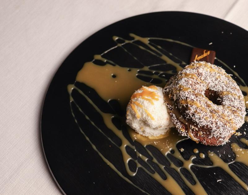 Caprese al cioccolato fondente e mandorle, gelato al cocco e salsa al caramello salato della casa